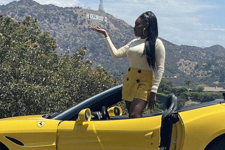 Posando junto al cartel de Hollywood a bordo del Ferrari